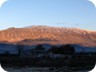 A little later, Mali i Buretos in the evening sun. The summit is covered in snow. From the summit towards the left is a ridge that ends in a bump. Beneath the bump is the town of Libohove. Our ascent goes more or less straight up from Libohove to the ridge, just right of the bump. From there it is easy to the summit.