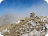 Approaching the last false summit, with the cairn. The clouds giving way to the main summit.